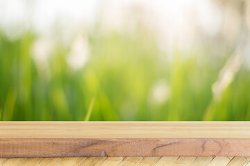 Wooden table top with blurred green grass background