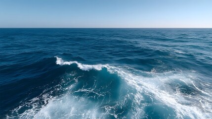 Fototapeta premium A vast expanse of deep blue ocean waves under a clear bright sky