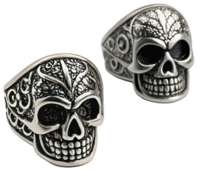 Highly detailed and intricately carved silver skull rings, featuring ornate floral and geometric patterns across the bone structure, are presented in a close-up, isolated on transparent background.