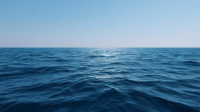 A tranquil vast expanse of deep blue ocean meets the clear blue sky at the infinite horizon