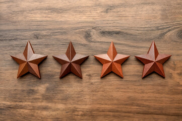 Wooden stars arranged in a row on a wooden surface in a bright workspace during the day