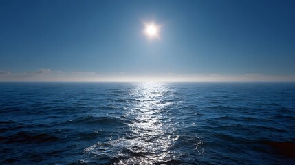 Bright sun illuminates vast ocean horizon creating a shimmering light path on tranquil blue waters