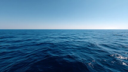 Fototapeta premium A vast deep blue ocean stretches to the clear horizon under a bright cloudless sky evoking a sense of immense natural beauty and tranquility