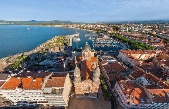 Aerial view of the Eglise Saint-Raphael standing proudly amid the terracotta rooftops, juxtaposed against the azure sea and the distant coastline, Marseille, Provence-Alpes-Cote d'Azur, France.