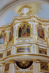 Obraz premium Beautiful golden iconostasis in an Orthodox Christian church featuring religious icons of Jesus Christ and saints with white and gold architectural details