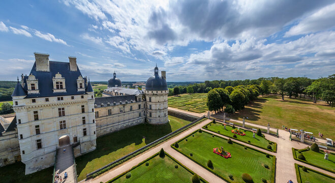 Aerial view of Chateau de Chaumont's pale stone walls meet lush green gardens under a sky of scattered clouds, Chaumont-sur-Loire, Centre-Val de Loire, France.