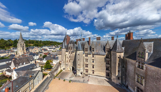 Aerial view of the Chateau de Chaumont, its stone walls glowing softly under the sun, contrasting with the deep blue sky and fluffy white clouds, Chaumont-sur-Loire, Centre-Val de Loire, France.