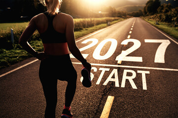 2027 start motivation concept with female runner on road symbolizing fitness goals, new beginnings and healthy lifestyle