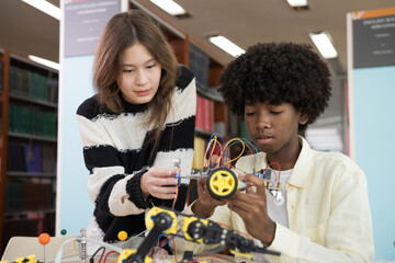 Group of student learning and checking electric current on toy robotics in library room at school. Robotics academy room. Technology and scientist at school concept