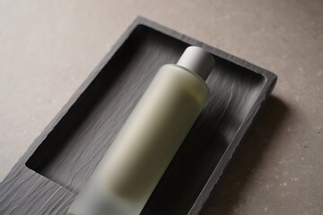 Bottle of lotion or perfume on wooden tray