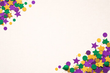 Vibrant Mardi Gras confetti scattered on white background for festive designs