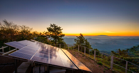 Close-up of a solar power plant in a mountain valley at sunset, reflecting golden light on photovoltaic panels
