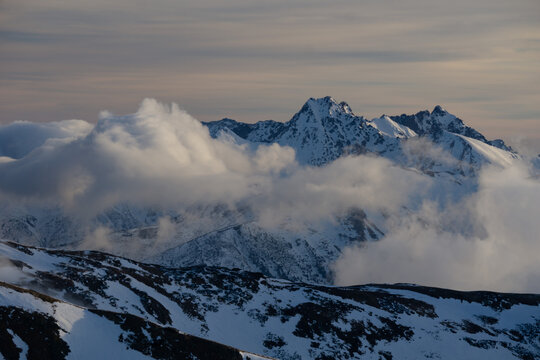 Aerial view of snow-capped mountain peaks pierce through a sea of swirling clouds, Nizna Bystra, Zilina Region, Slovakia.