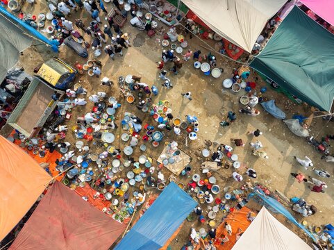 Aerial view of a bustling street market with vibrant stalls and crowds of people, a tapestry of colors and activity unfolds, Tongi, Dhaka Division, Bangladesh.