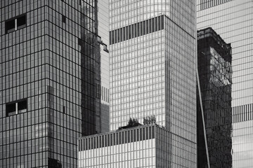 Fototapeta premium Low-angle view of modern skyscrapers in Manhattan, New York City. This dramatic perspective emphasizes the towering height and sleek design of the city's contemporary architecture. 