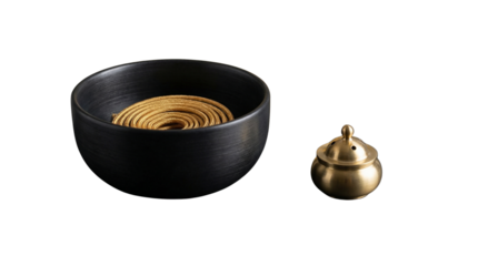 Black bowl with golden spiral and small bronze container on white background