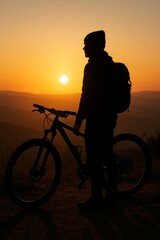 Obraz premium Silhouette of cyclist at sunset in mountains. Peaceful moment captures nature's beauty. Vertical composition highlights adventure and outdoor lifestyle. Perfect for travel and fitness themes.