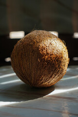 Coconut on a wooden table with sunlight.