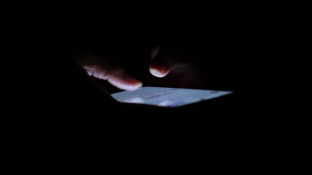 Person Using Smartphone in Dark Room.