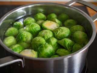 Cooking Brussels sprouts in pot on electric stove