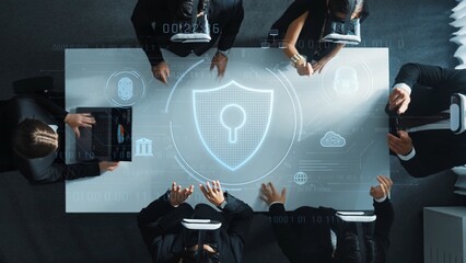 A group of business professionals collaborates on cybersecurity strategies using virtual reality technology, surrounded by digital protection graphics in a modern meeting space. Raster