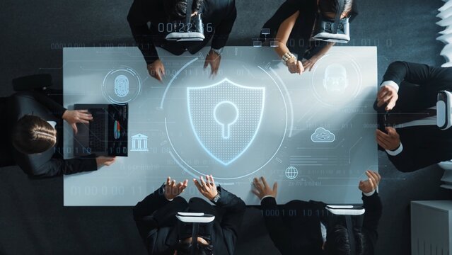 A group of business professionals collaborates on cybersecurity strategies using virtual reality technology, surrounded by digital protection graphics in a modern meeting space. Raster - Powered by Adobe