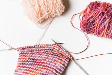 Hand knitting wool socks on white background. Process of knitting. Hand made.