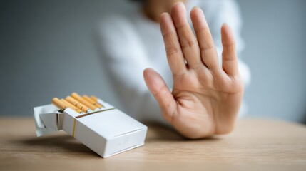 Individual with hand raised in a stop gesture, rejecting cigarette pack on wooden table, symbolizing commitment to a smoke-free lifestyle and health awareness
