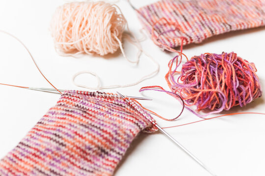 Hand knitting wool socks on white background. Process of knitting. Hand made.