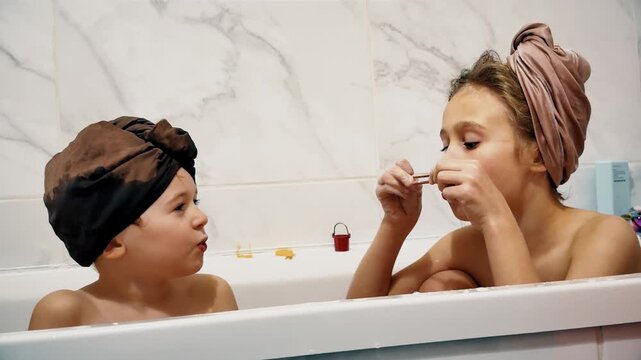 Two children playing with bath foam together at home during evening routine