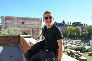 Fototapeta premium Smiling Happy tourist boy with sunglasses near Fori Imperiali enjoying the city at Rome during language vacation.Concept family travel trip happy language vacations in Rome