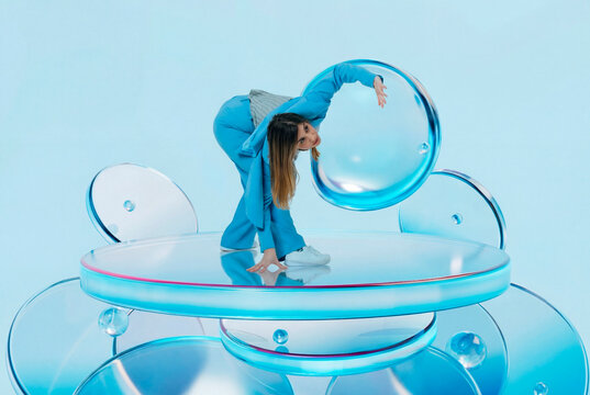 Woman bending forward while interacting with floating 3D glass discs
