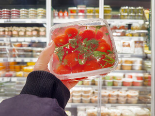 choosing a can of tomatoes in a supermarket