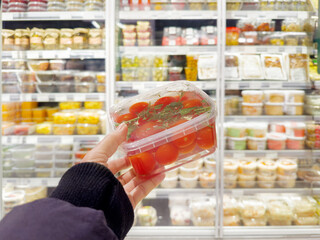 choosing a can of tomatoes in a supermarket