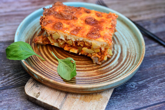Potato and minced meat  Casserole  with   parmesan cheese and garlic on wooden rustic bakcground.  Bulgarian moussaka