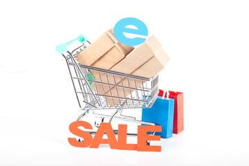Online shopping concept with supermarket cart filled with boxes and sale sign