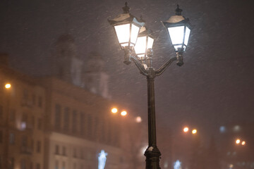 Snowfall in the evening city under the streetlights. Winter Minsk