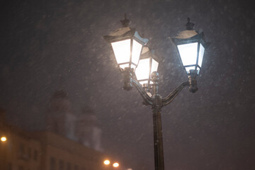 Snowfall in the evening city under the streetlights. Winter Minsk