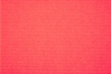 Fototapeta premium Corrugated cardboard background with red texture. Minimal recycled paper surface for eco design, packaging, craft projects, sustainability concepts and copy space.