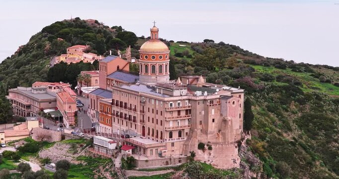 Aerial view of the Sanctuary of Tindari, a monumental building with a golden dome, perched on a cliff overlooking the sea, Tindari, Sicily, Italy.
