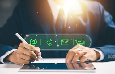 Businessman using tablet with digital contact icons, representing business communication, customer support, contact information, omnichannel service, and modern digital interaction strategy.