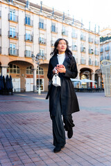 Latina businesswoman of asian descent walking in city square