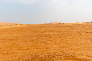 Obraz premium Some distant vehicles move along the landscape. Trash scattered in the foreground, illustrating the problem of desert pollution.