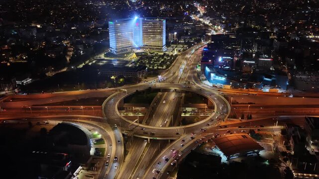 Aerial drone night video of illuminated multilevel ring road junction crossing Attiki Odos and National motorway in Northern Athens, Attica, Greece