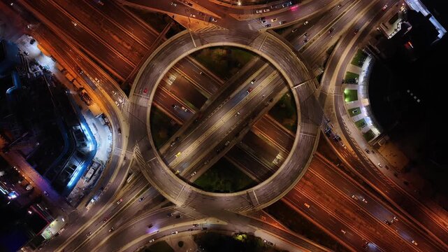 Aerial drone night video of illuminated multilevel ring road junction crossing Attiki Odos and National motorway in Northern Athens, Attica, Greece