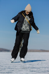 Woman ice skating on frozen lake enjoying winter activity