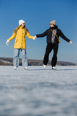 Women ice skating holding hands on frozen lake