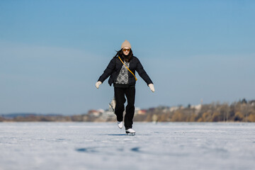 Young woman ice skating on frozen lake in winter