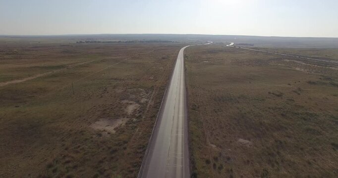 Straight Highway Through Vast Grassland Prairie - Aerial View