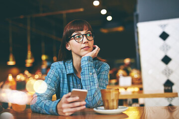 Break, phone and planning with woman in coffee shop for ideas, social media or vision. App, communication and thinking with customer person in cafe or restaurant for service and hospitality at night
